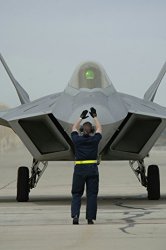 Home Comforts An Air Force Crew Chief Directs The Pilot Of F-22A Raptor Aircraft To A Parking Spot On The Ramp Aft
